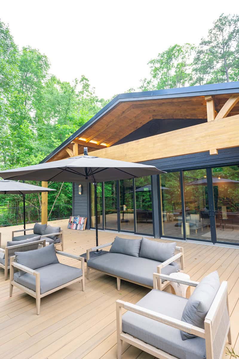 A cozy outdoor deck with comfortable couches and colorful umbrellas.