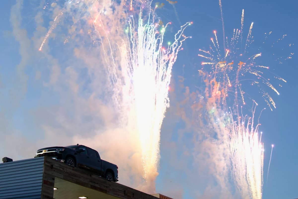 a truck on a roof with fireworks in the sky