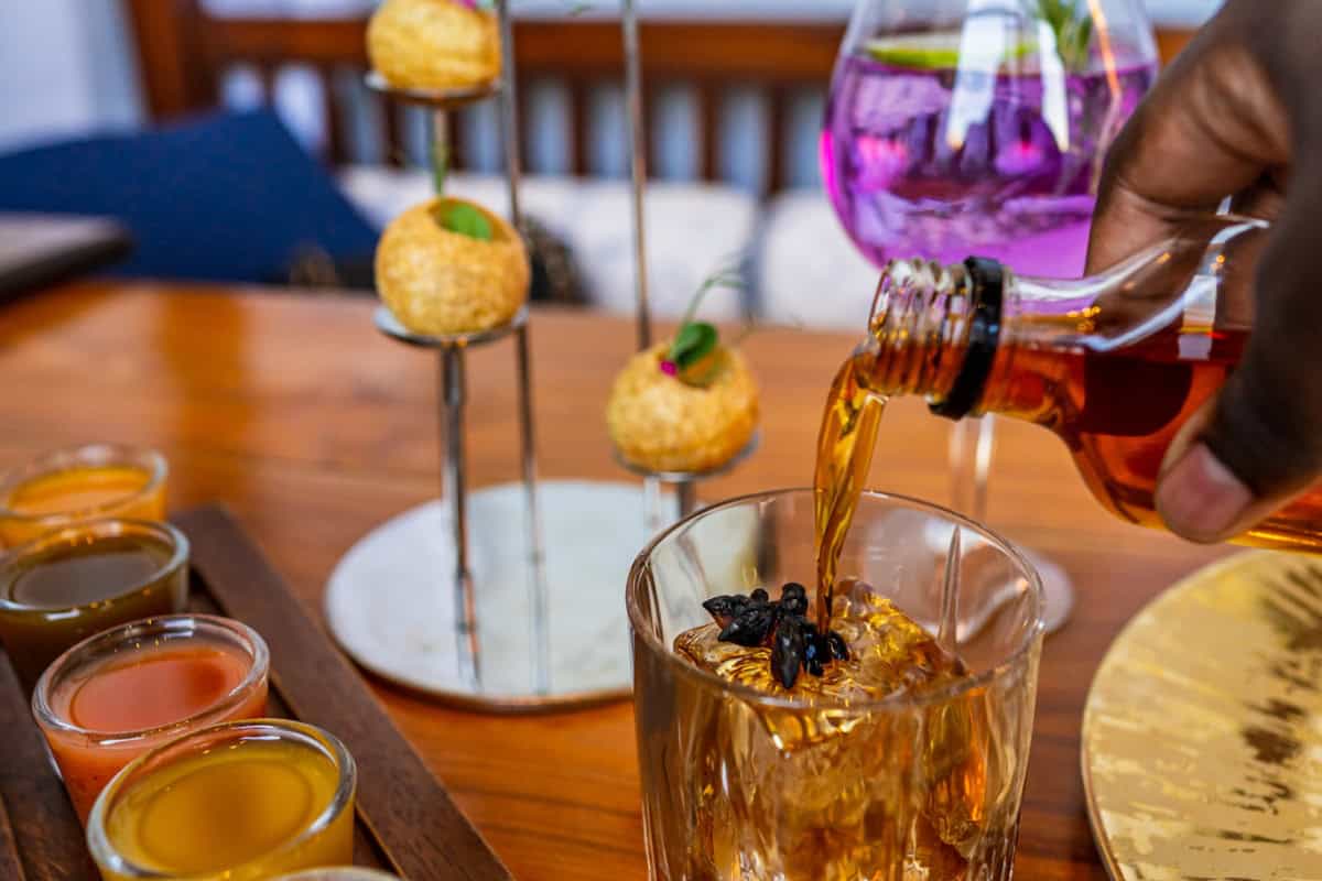 a person pouring a drink into a glass