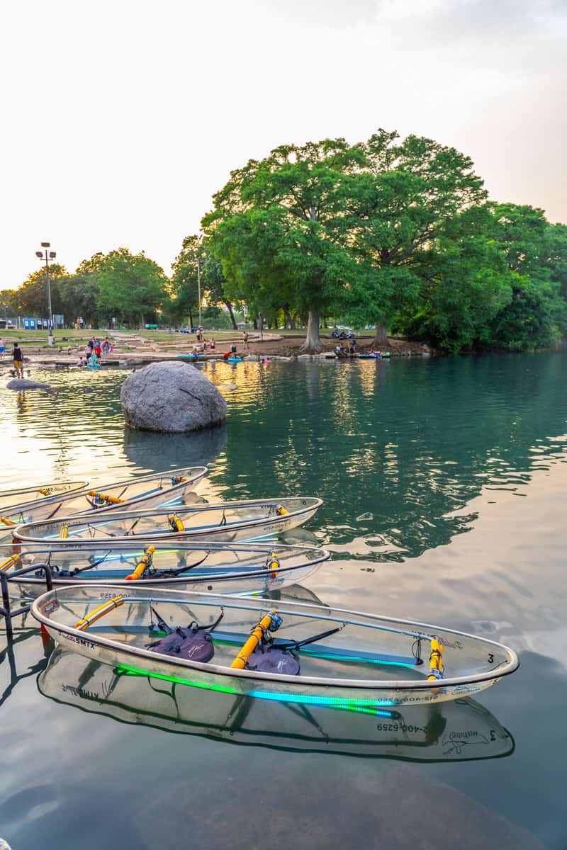 Several crystal kayaks  floating on calm water.