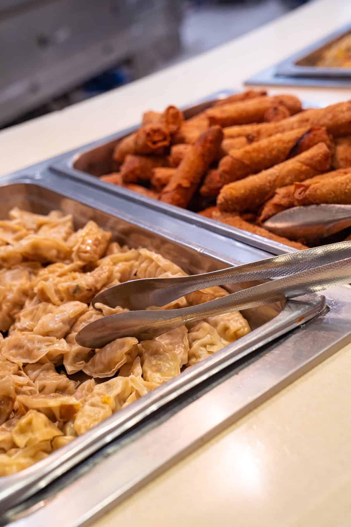 a tray of food with tongs