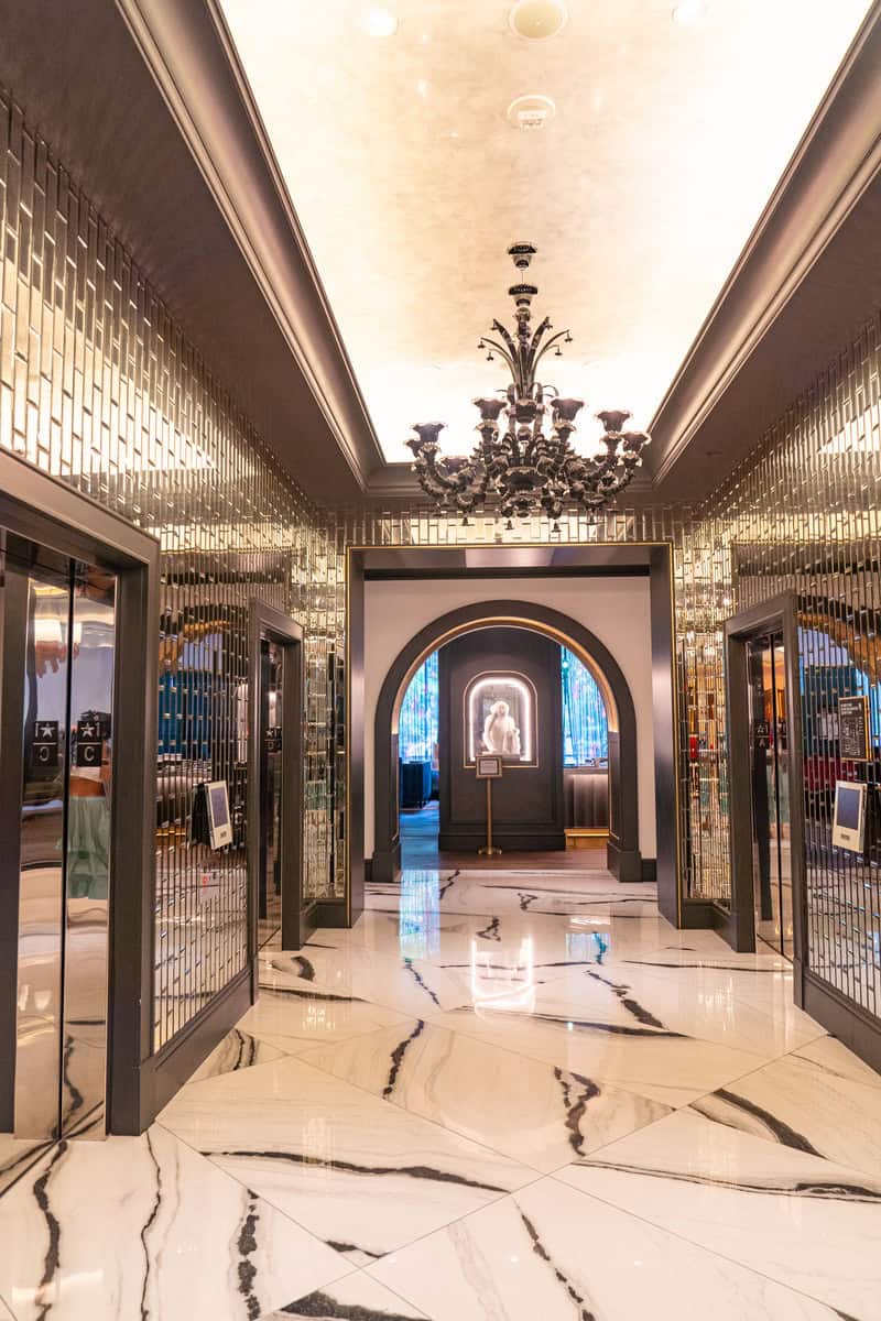 A luxurious lobby with marble floors and a sparkling chandelier.