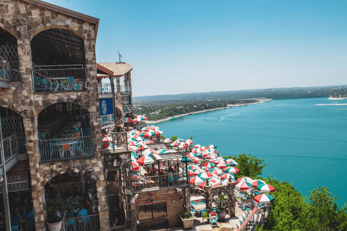 a building with umbrellas and a body of water