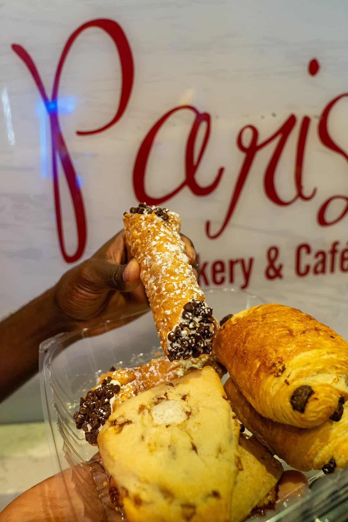 a hand holding a bowl of pastries