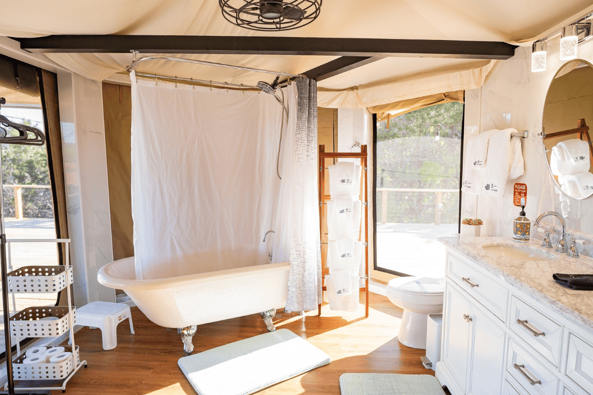 a bathroom with a tub shower curtain and a toilet