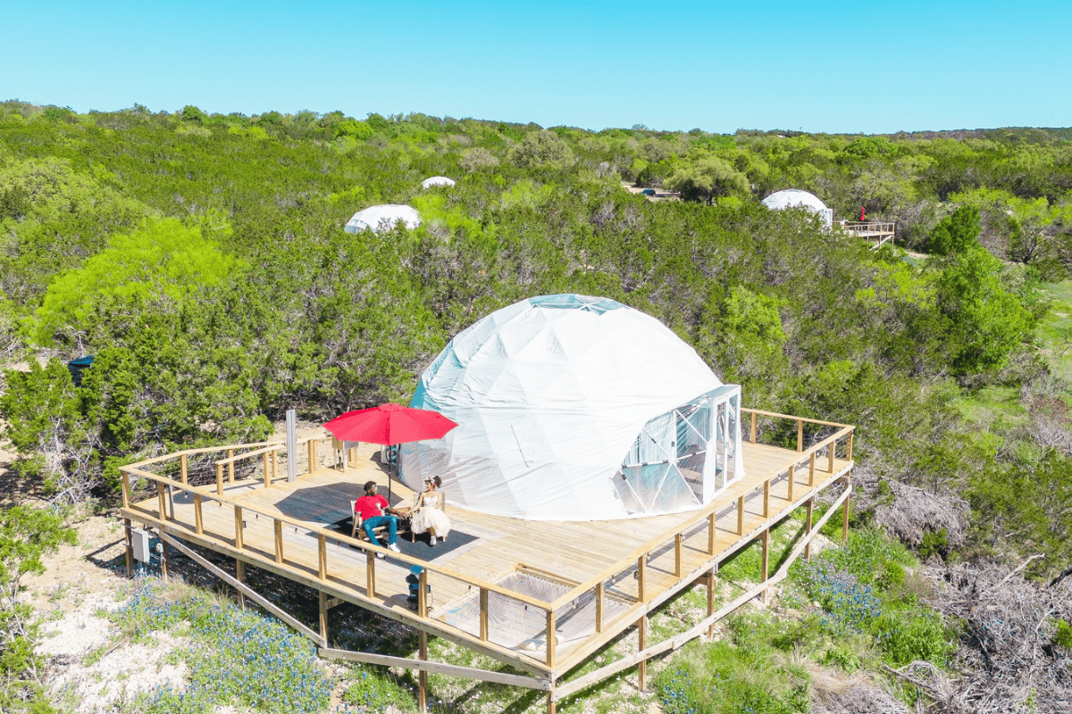 Dome tents arranged on hillside with scenic view.