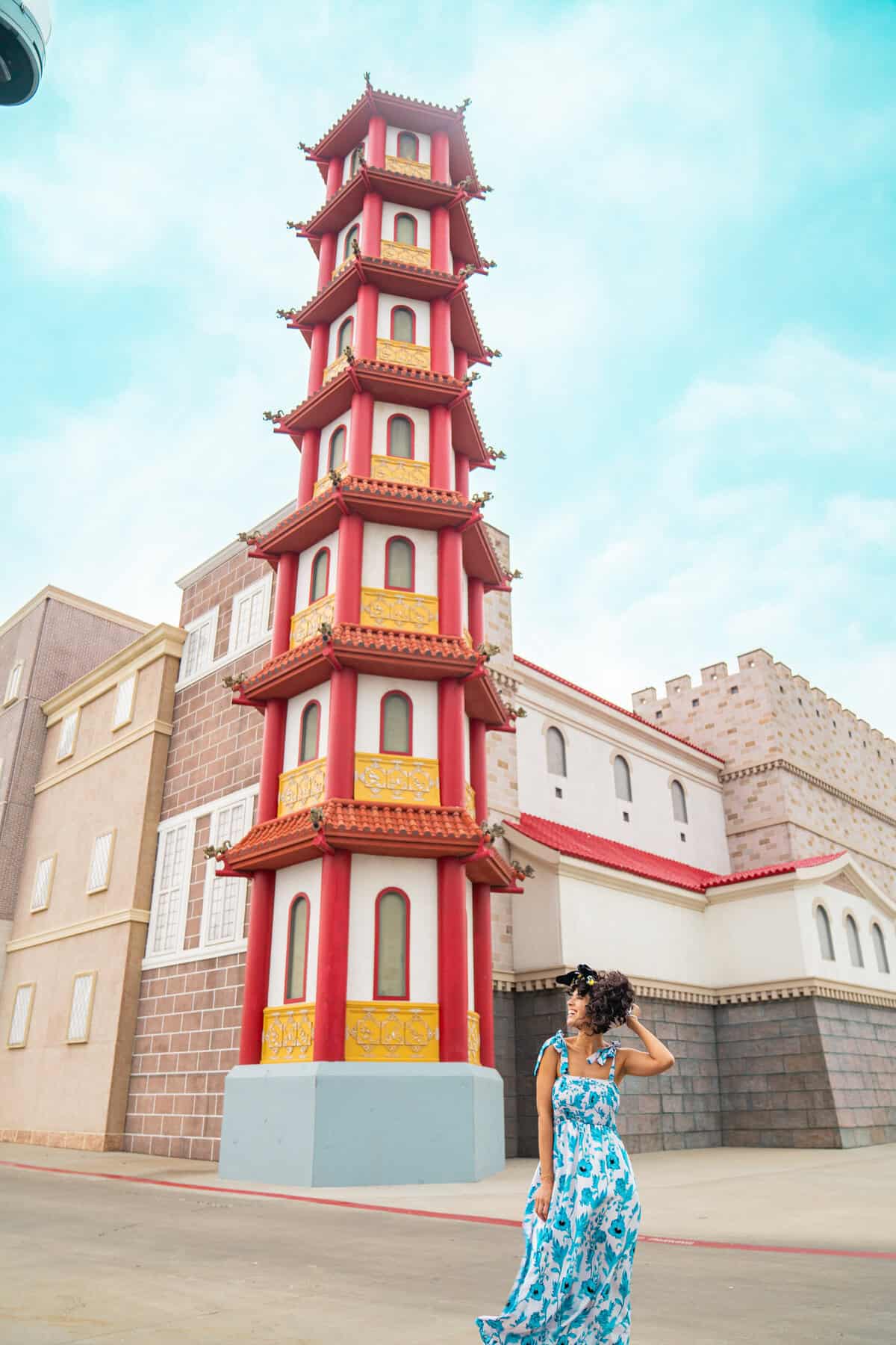 a woman standing in front of a tall tower