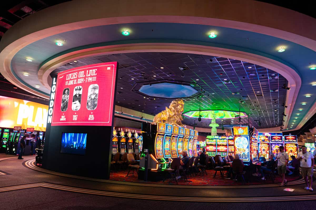 a casino with slot machines and people sitting in chairs