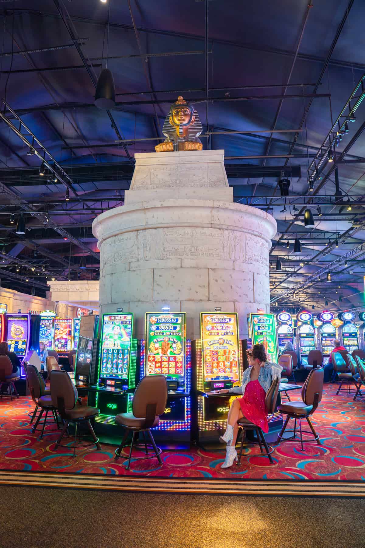 A colorful casino floor with slot machines and ornate carpeting.