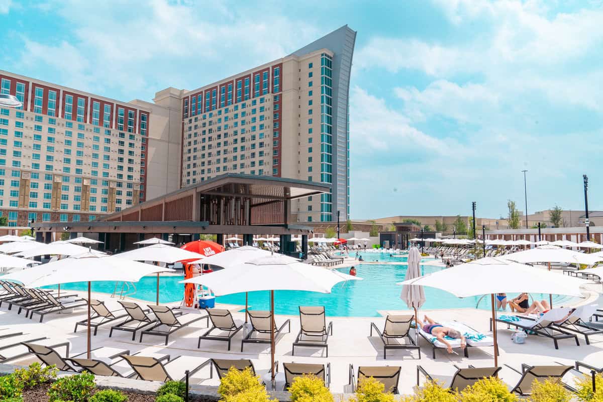 a pool with umbrellas and chairs and a building