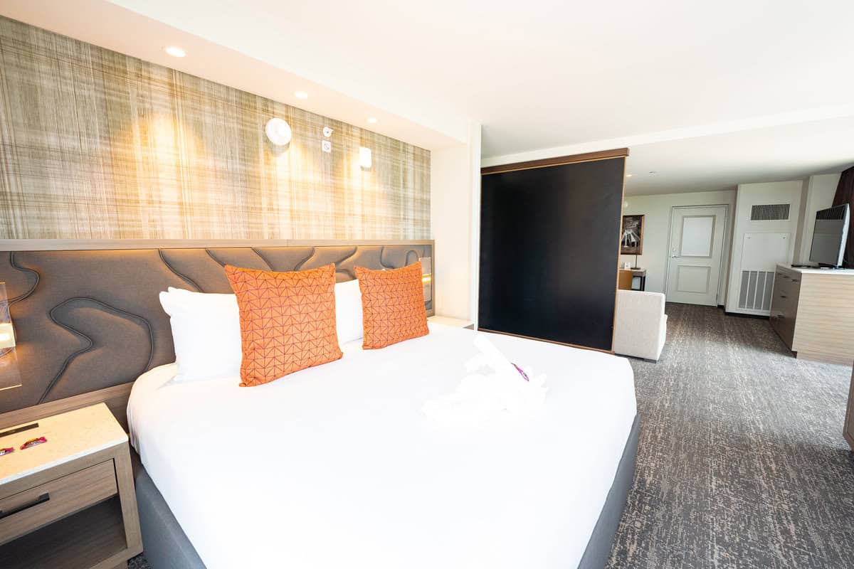 a bed with orange pillows in a hotel room