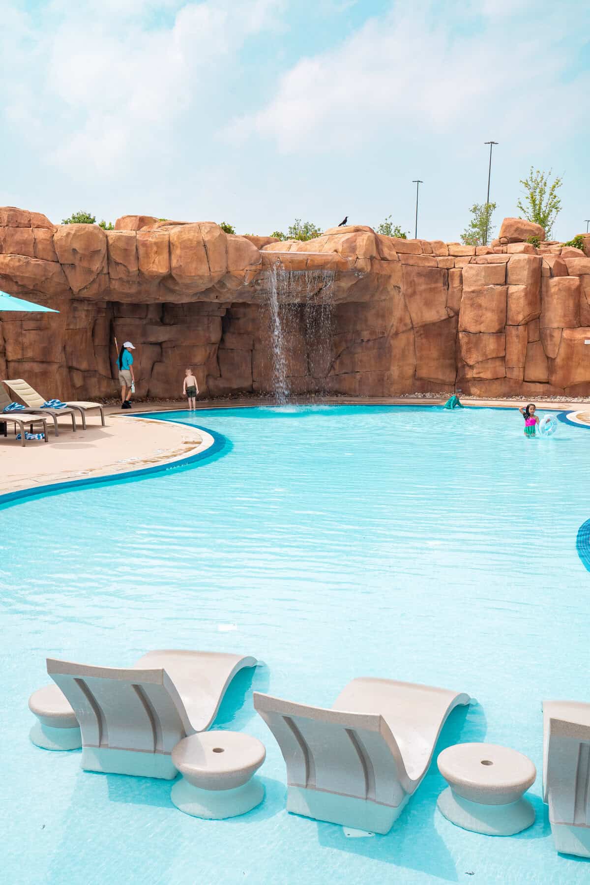 a pool with a waterfall and people in it