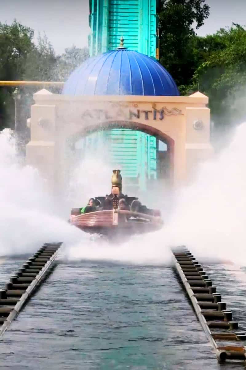 A water ride with people splashing down beneath an "Atlantis" arch.