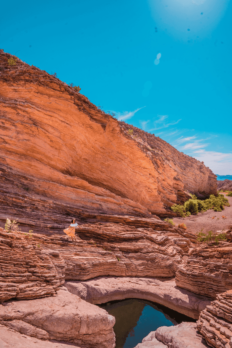 Person in yellow dress standing near rock pools