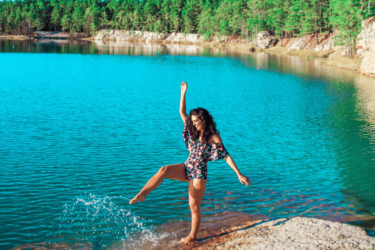 Person kicking water on a rocky lakeshore