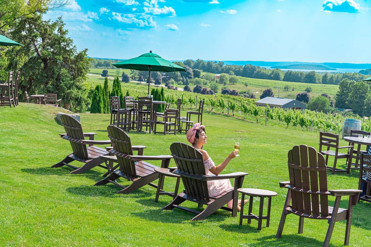 A scenic winery with Adirondack chairs overlooking vineyards 