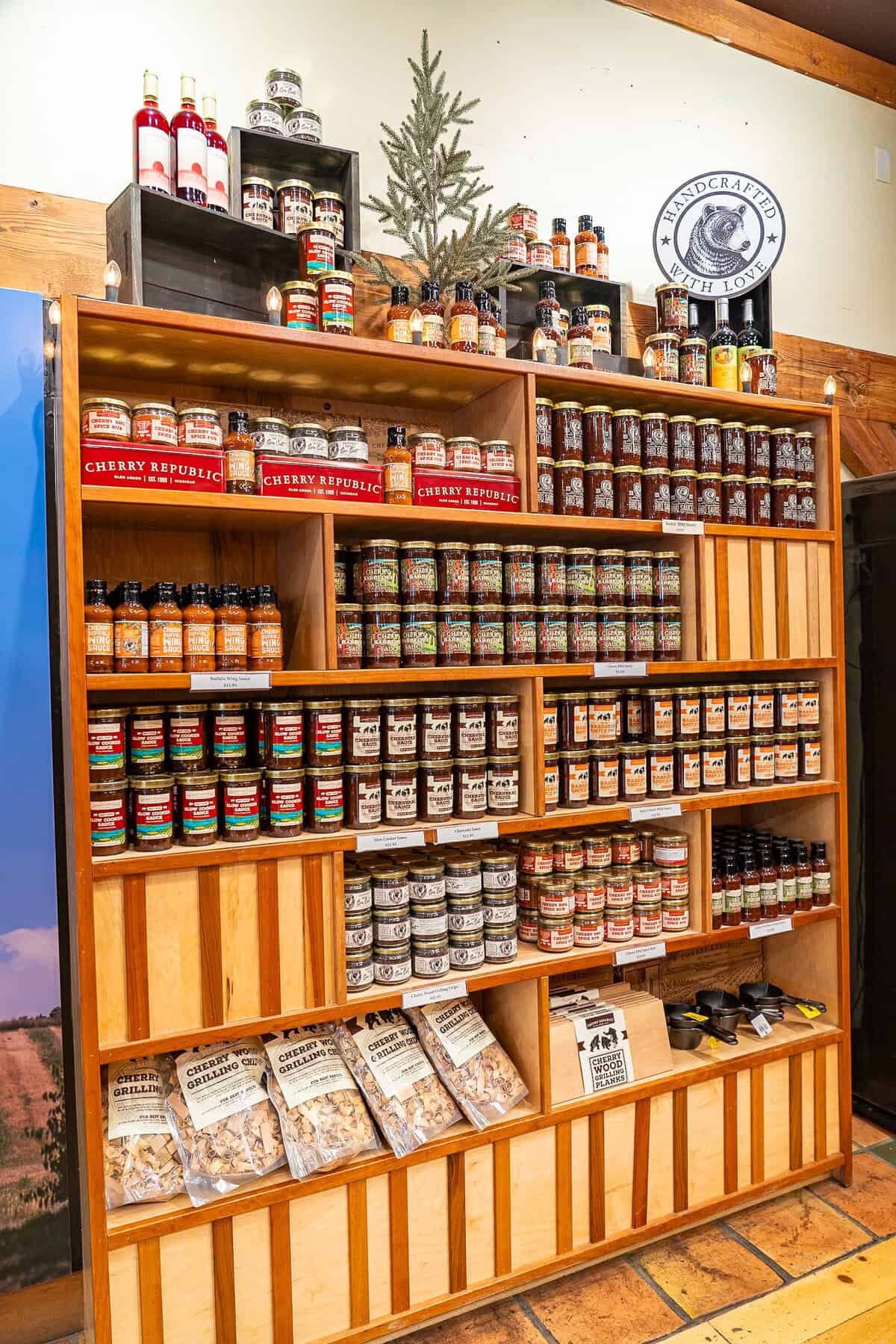 Wooden shelf stocked with various cherry-themed products in a store.