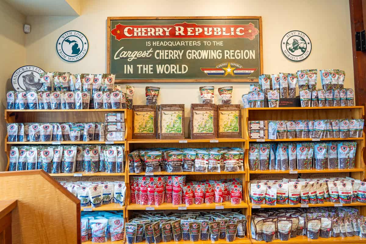 Interior store shelf with various cherry products and a sign stating "Largest Cherry Growing Region."