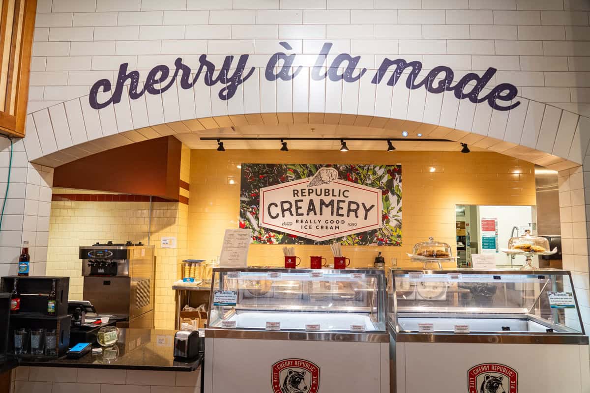 Ice cream shop interior with "cherry à la mode" on the wall and ice cream freezers.