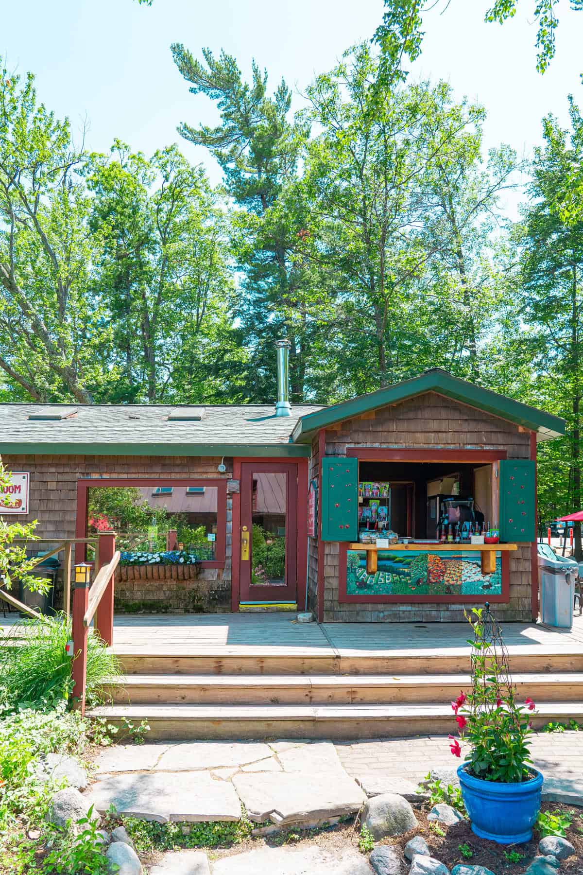 Rustic wooden snack shack in a forested area with clear blue sky.