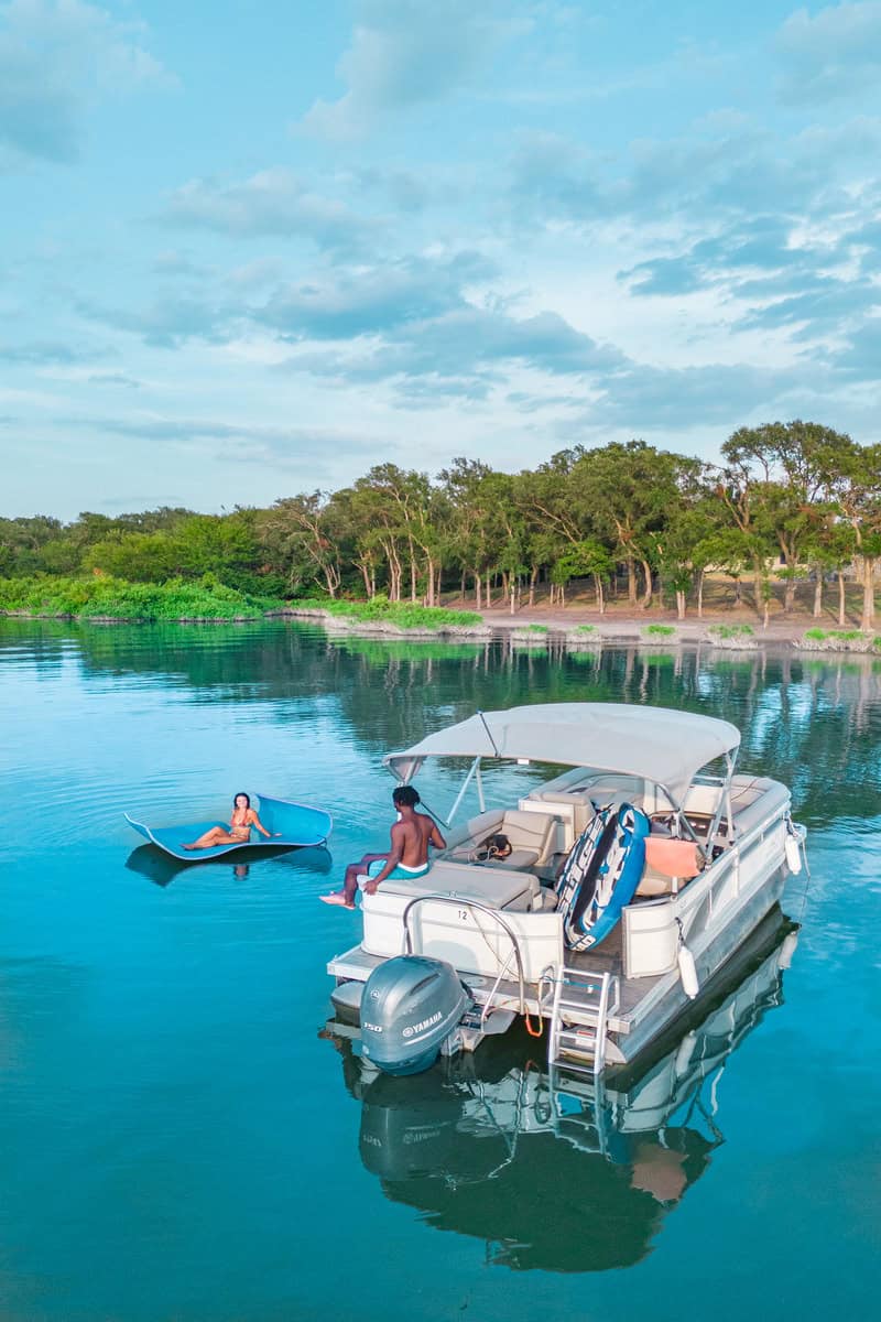 Two people relaxing by a pontoon boat