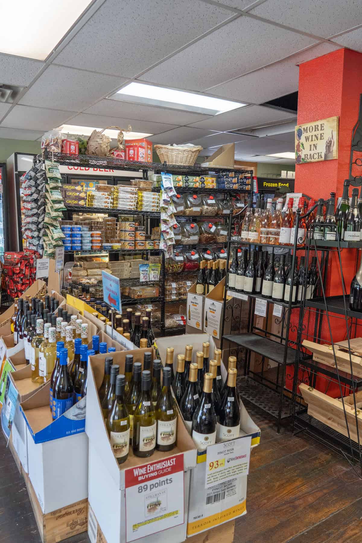 Interior of a liquor store with shelves of wine bottles and snacks.