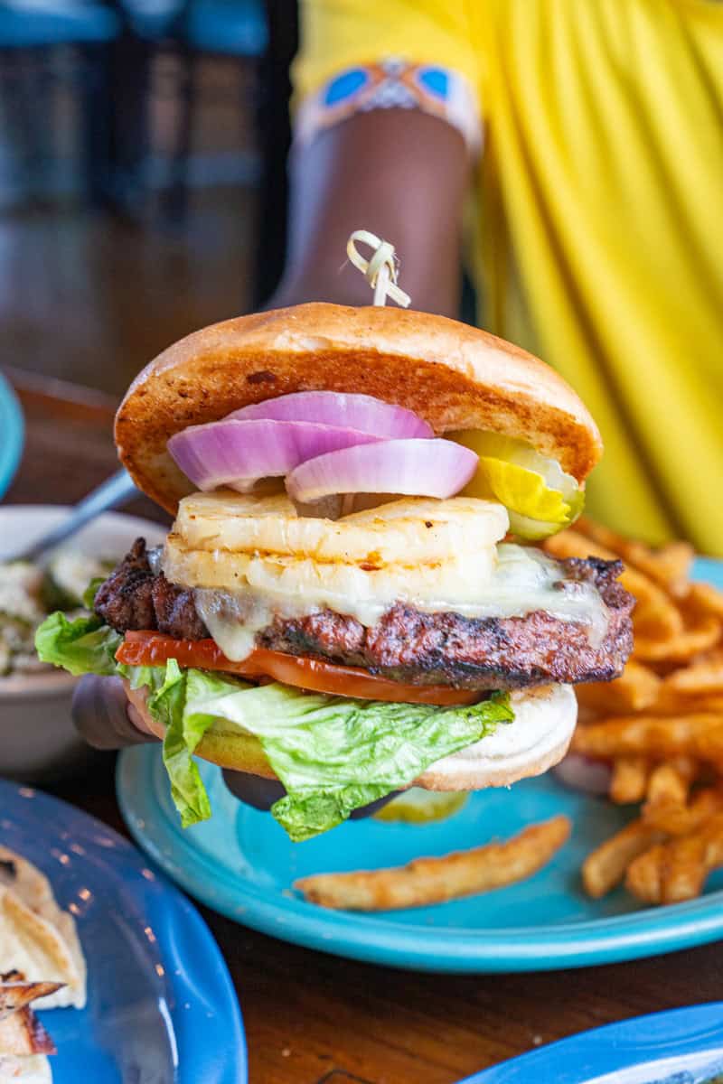 Juicy burger with cheese, pineapple, lettuce, and onion