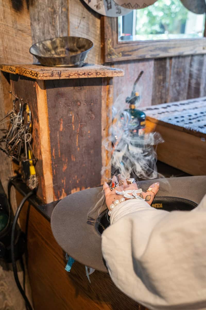 Person holding smoldering sage bundle