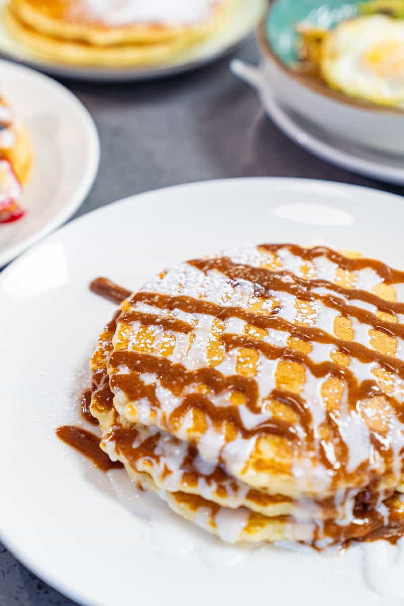 A stack of pancakes topped with caramel drizzle