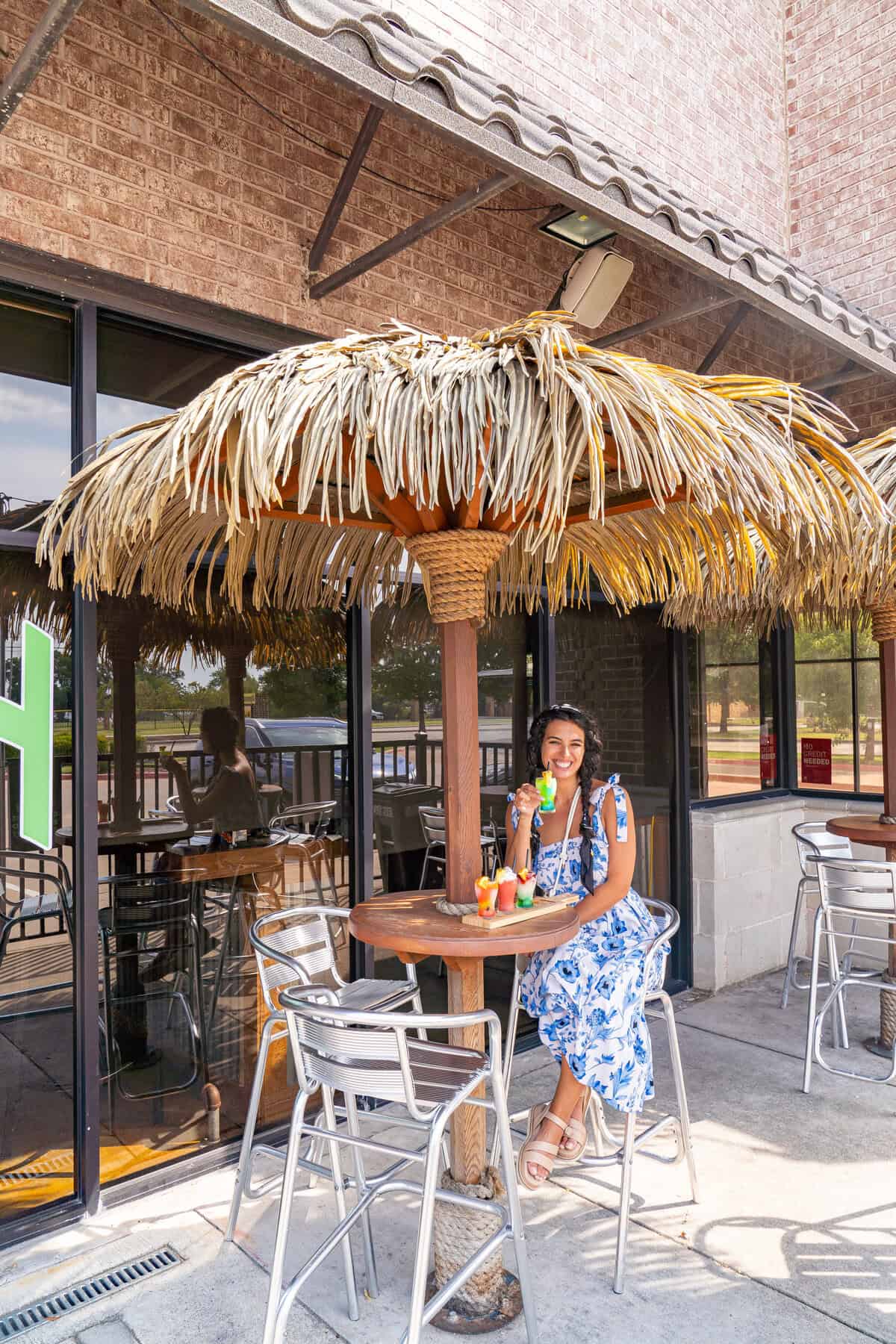 A person sitting under a thatched umbrella