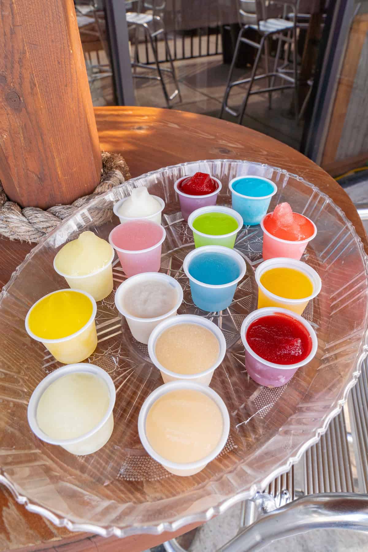 Assorted colorful cocktails in small plastic cups