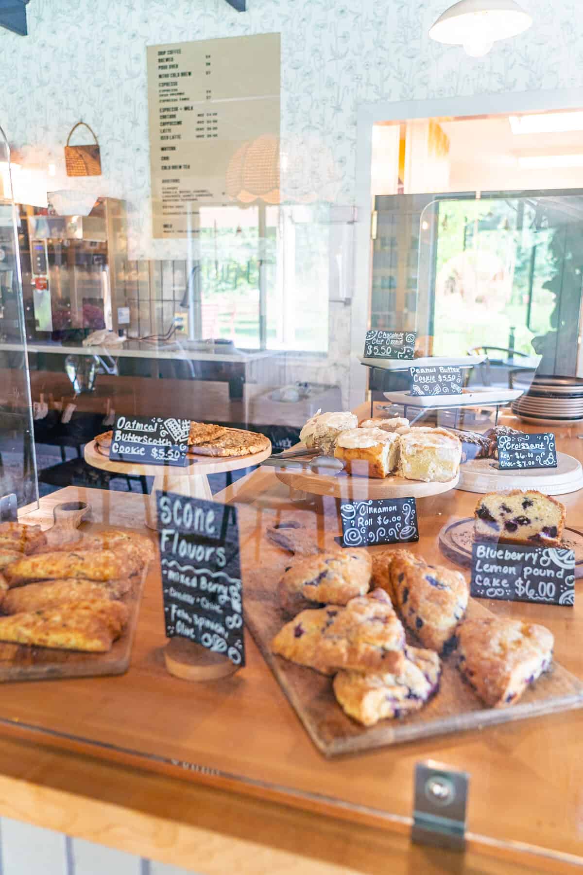 A bakery display case filled with various scones and cakes, with price tags visible.