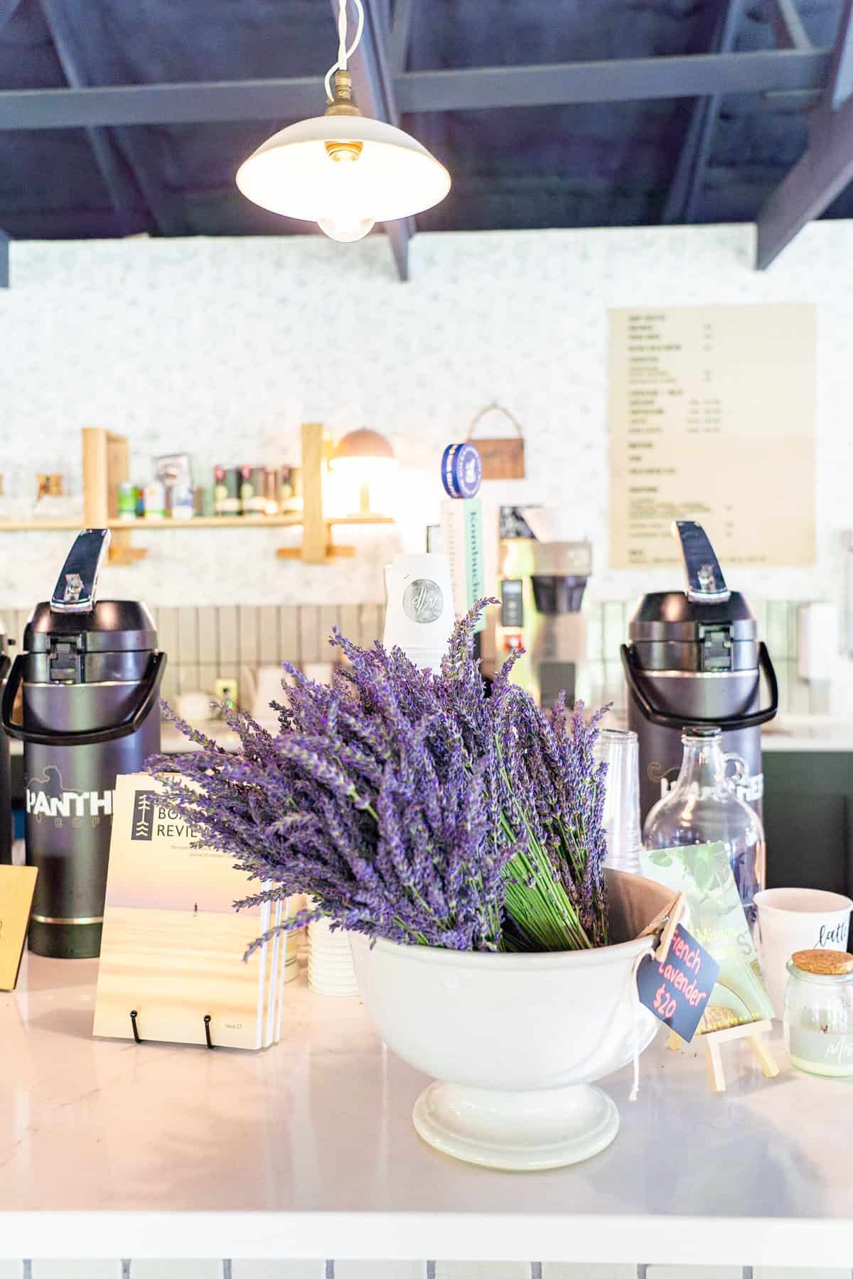 A cozy café counter with lavender bouquets for sale under a hanging light.