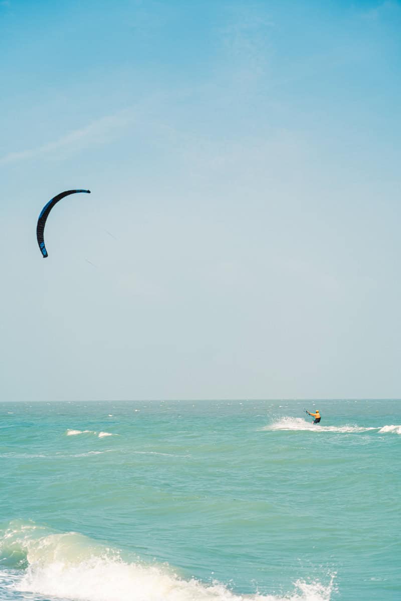 Kitesurfer on the ocean with a blue sky.