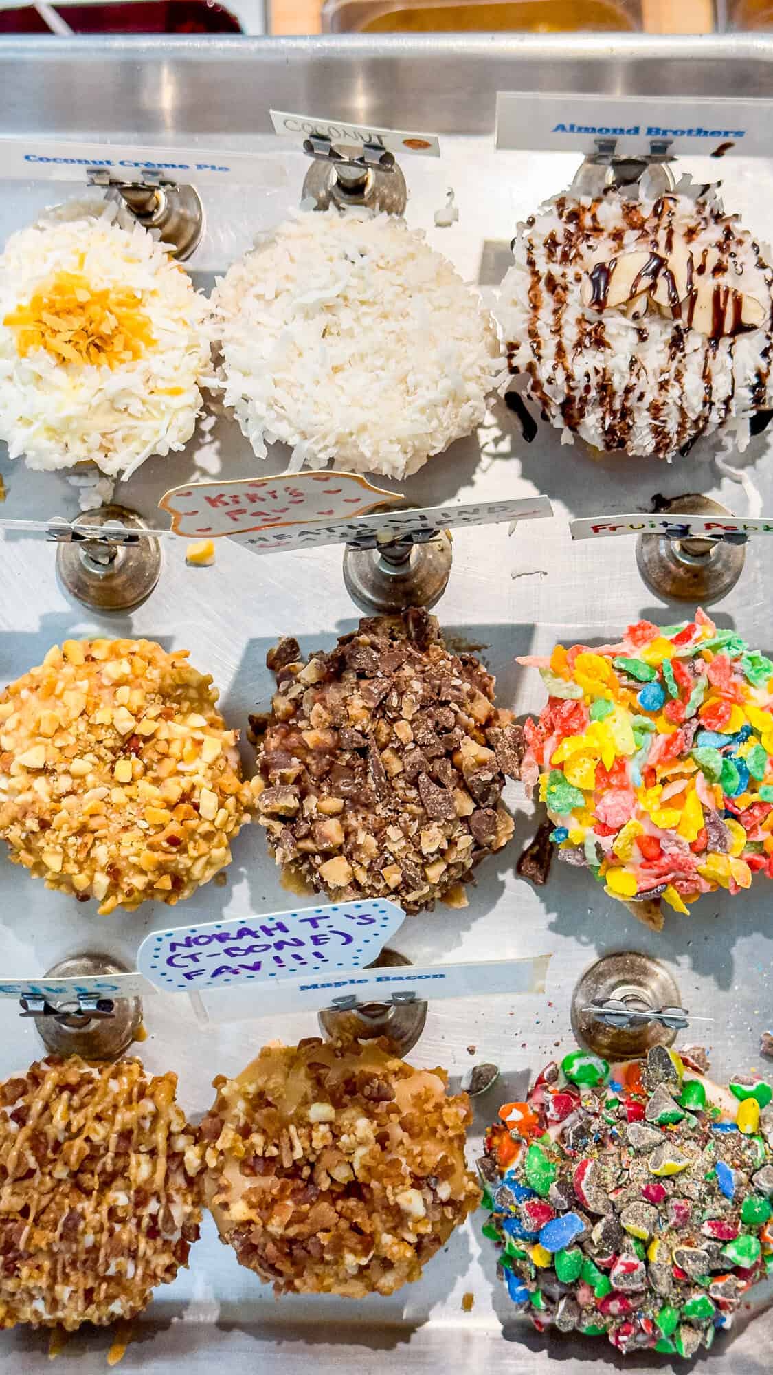 Assorted donuts with various toppings, including coconut, nuts, and colorful candies.