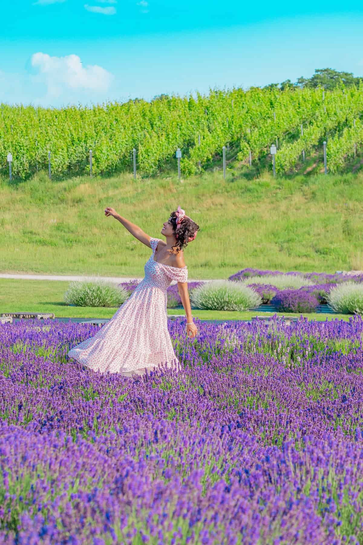 Woman in a floral dress twirling in a lavender field 