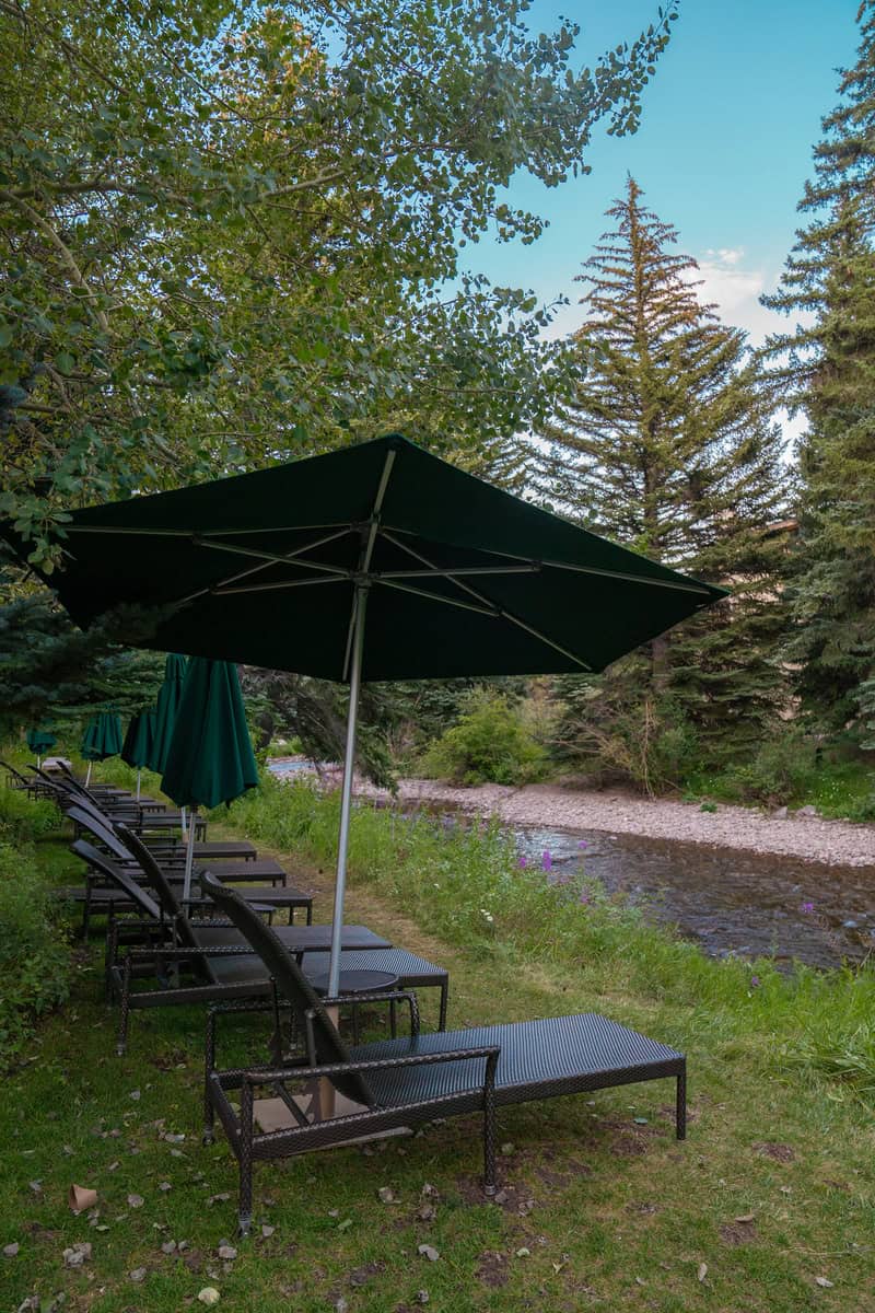 Sun loungers and an umbrella by a creek