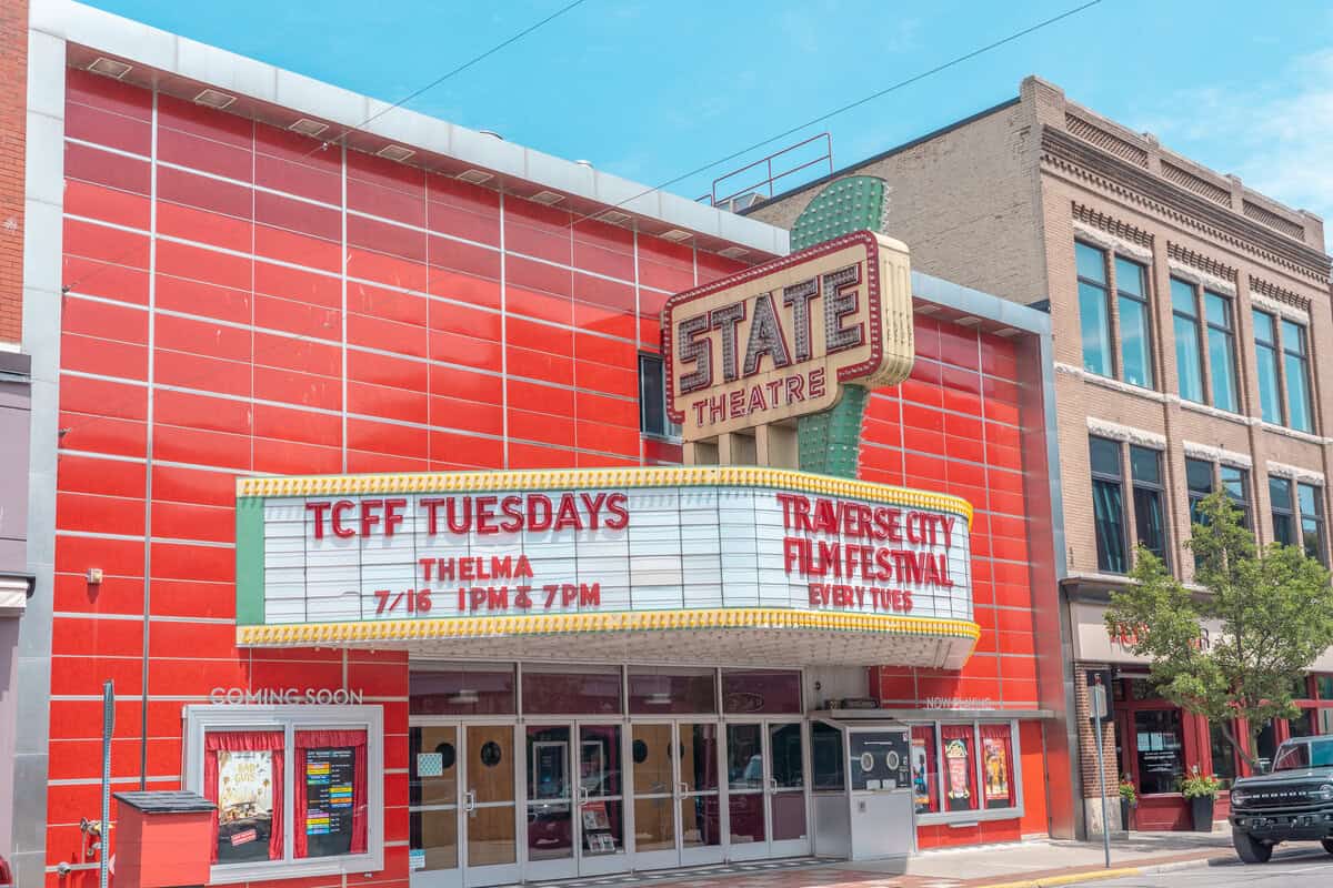 Red and white State Theatre exterior with marquee advertising TCFF Tuesdays and Traverse City Film Festival.