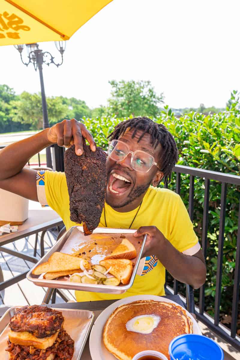 Person holding a large BBQ rib