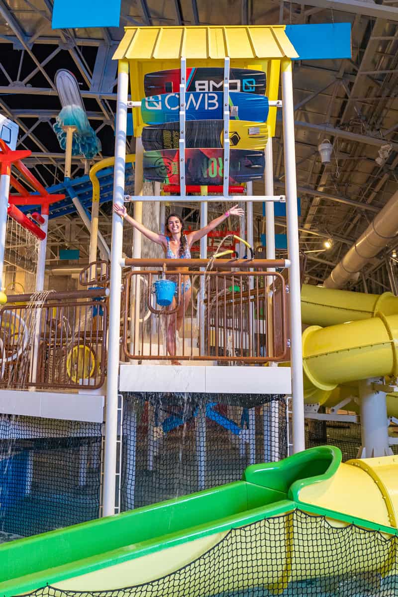 A colorful indoor water park structure with slides and a water bucket.