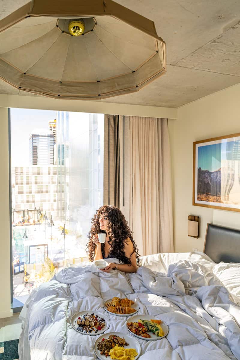 Person on a bed with breakfast trays