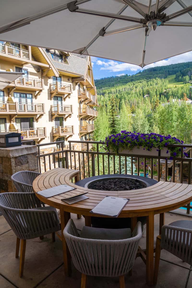 Balcony with a fire pit table overlooking a forest