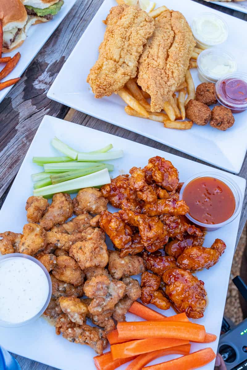 Plates of fried catfish, fries, hushpuppies, and buffalo wings