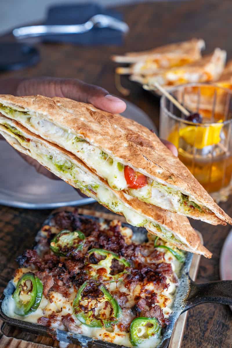 A hand holding a stuffed flatbread sandwich