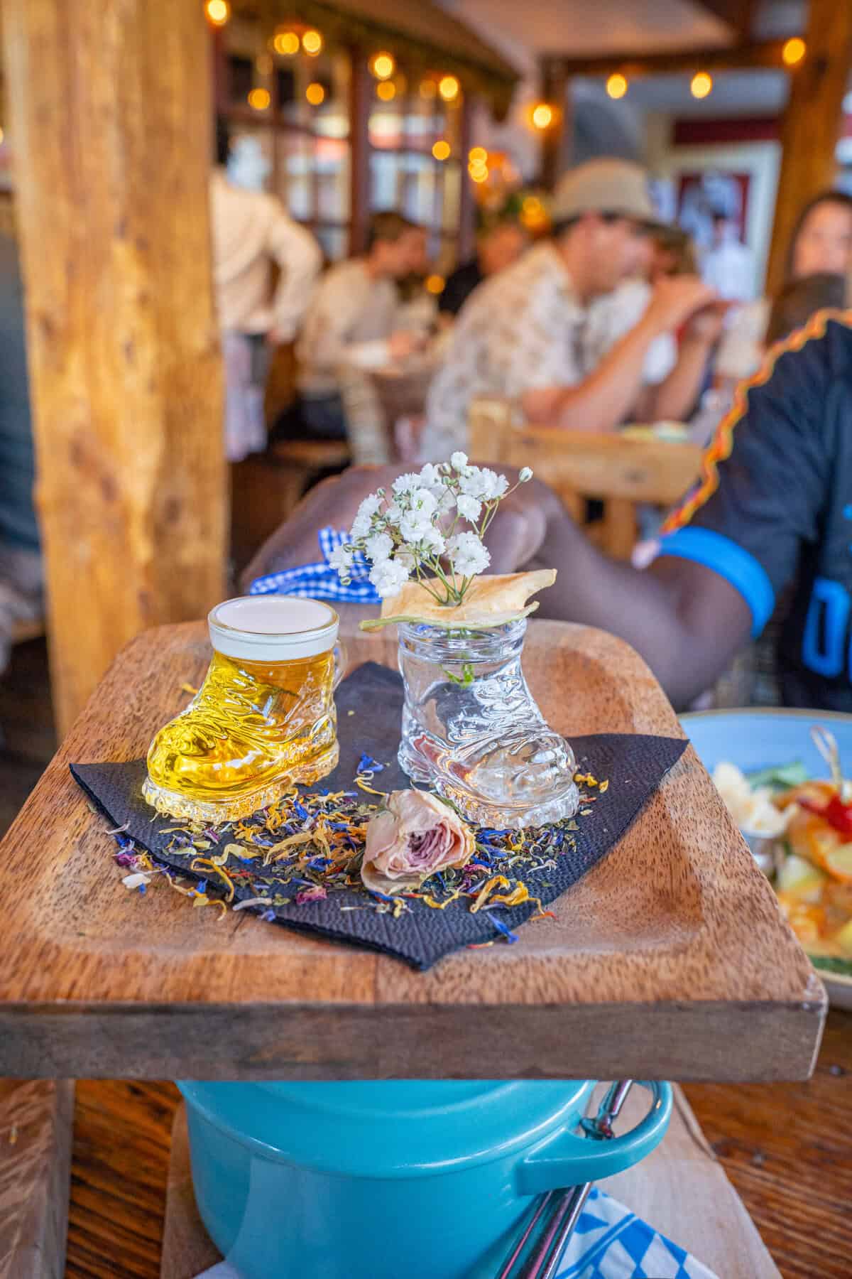 A glass boot filled with beer on a wooden board