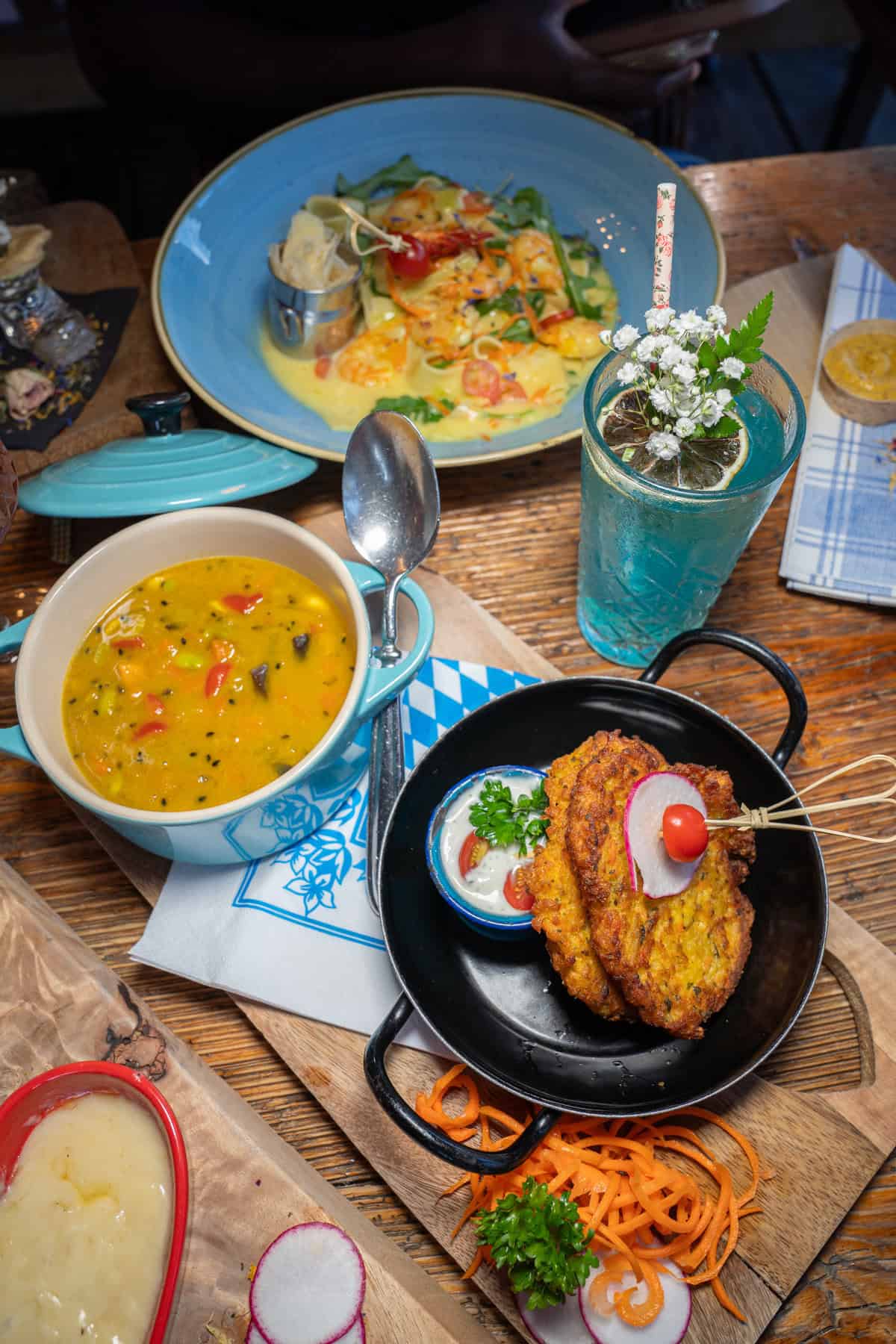 A table with various dishes, including soup, a drink