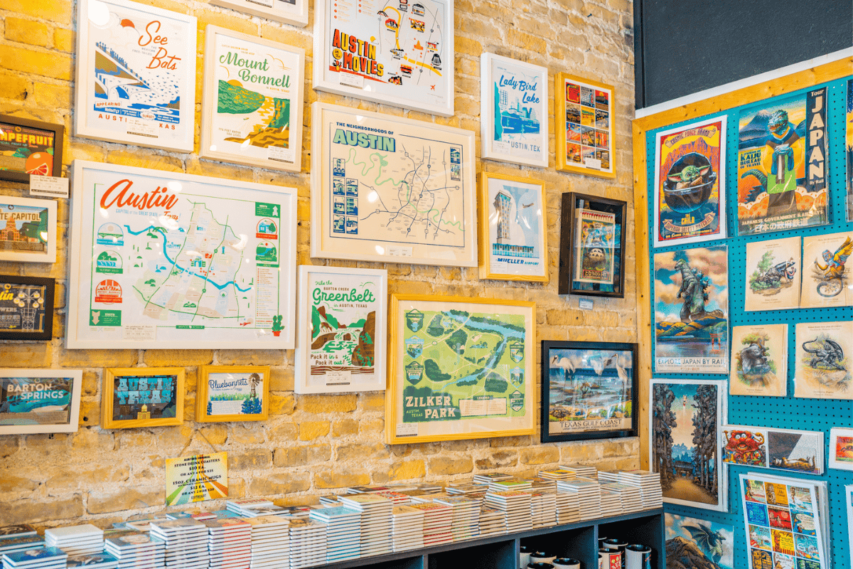 A colorful wall filled with framed posters and maps