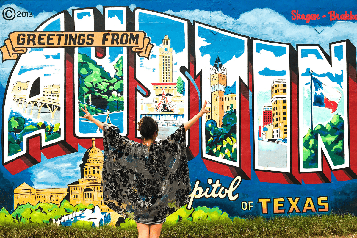 A woman standing on an Austin mural 