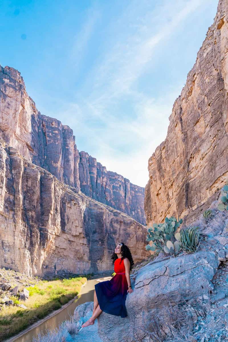 Person in a red and blue dress sitting on a rock