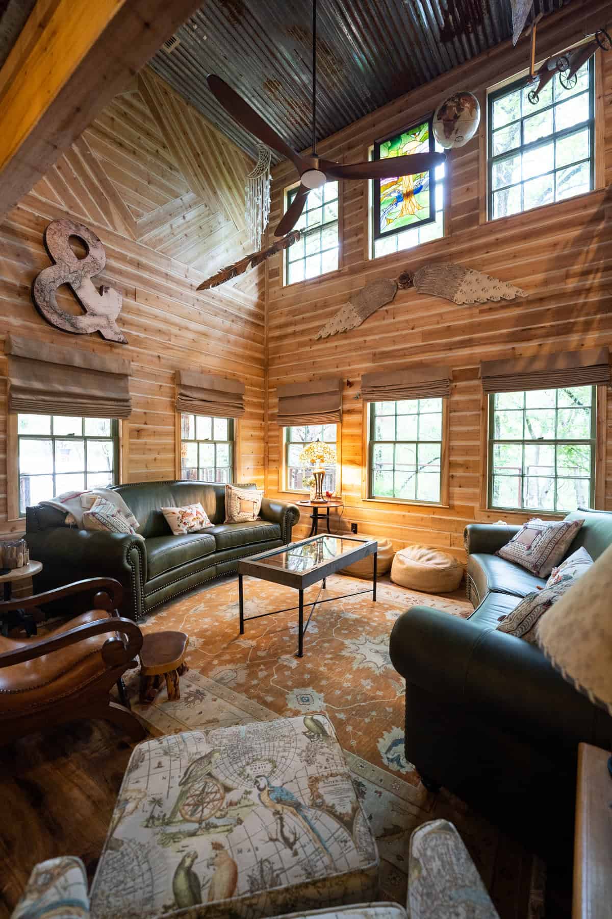 Cozy log cabin living room with leather furniture and rustic decor.